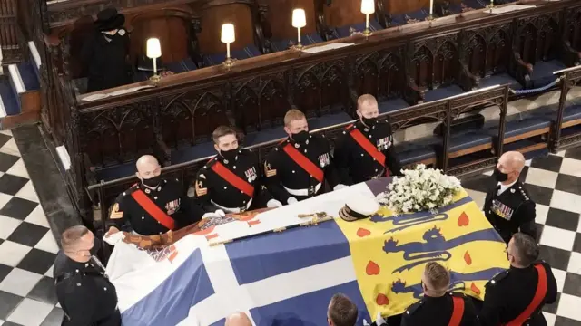 The Queen sits alone as the Duke of Edinburgh's coffin is brought into St George's Chapel, Windsor
