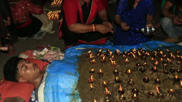 आफ्नो शरीरमा बत्ती बाली बसेका एक भक्तजन
