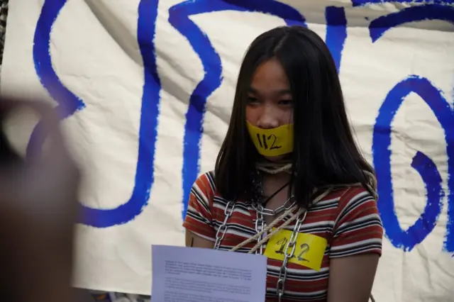 ผู้ประท้วงใช้เทปปิดปากเขียนคำว่า 112