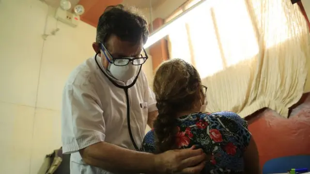 Padre Portillo examinando uma paciente