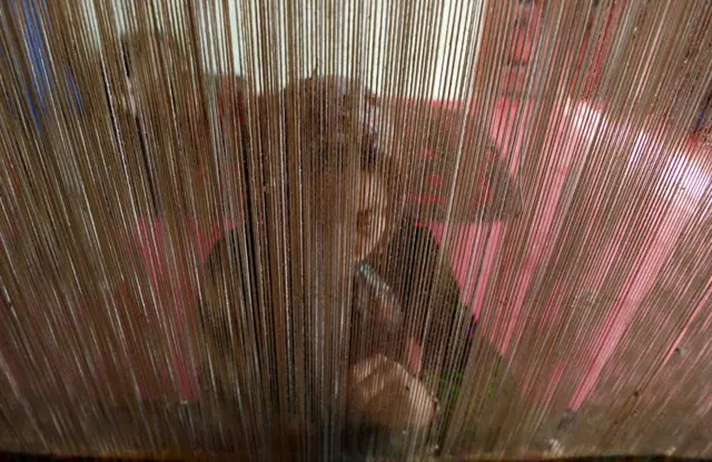 یک زن افغان پشت دار قالین 