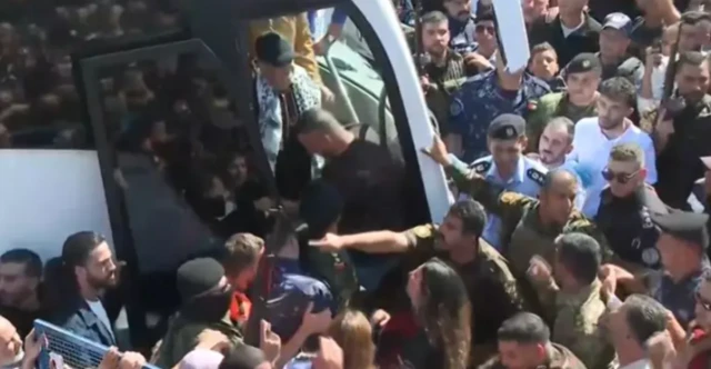 Os ônibus que transportavam prisioneiros palestinos , com multidão ao redor