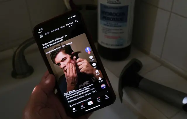 صورة من مقطع فيديو لناشط مؤثر على تطبيق تيك توك وهو يضرب عظم وجنته بمطرقة في مسعى إلى الحصول على فكّ محدّد الزوايا، لوس أنجلوس بتاريخ 11 أبريل/ نيسان 2025.