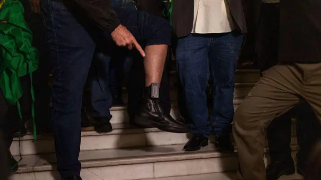 Tornozeleira eletrônica sendo exibida por Jair Bolsonaro. 