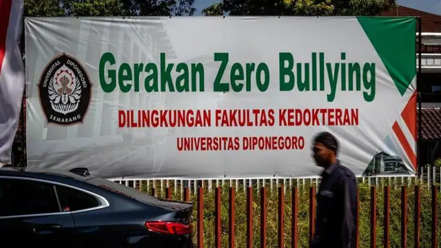 Seorang petugas keamanan berjalan di samping spanduk kampanye Gerakan Zero Bullying yang terpasang di lingkungan Fakultas Kedokteran Universitas Diponegoro (UNDIP), kawasan kompleks RSUP Dr Kariadi, Kota Semarang, Jawa Tengah, Kamis (15/8/2024).