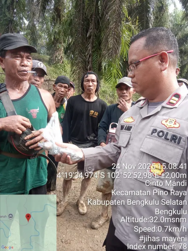 Seorang petugas kepolisian memegang barang bukti berupa revolver dalam bungkus plastik.