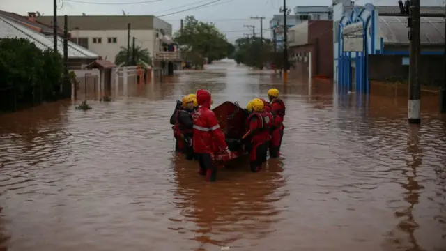 Bombeiros resgatando pessoas em bote durante