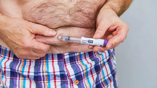 Homem injetando em si próprio uma medicação à base de GLP-1 para emagrecer