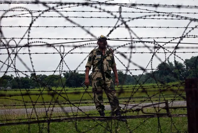 সীমান্তে কাঁটাতারের বেড়ার পাশে প্রহরারত ভারতীয় সীমান্তরক্ষী