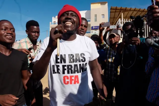 Des sympathisants font la fête dans une rue de Dakar après que le tribunal a décidé de libérer le militant Kemi Seba de la prison de Rebeuss, le 29 août 2017. Kemi Seba avait été arrêté après avoir brûlé un billet de 5 000 francs CFA lors d'un rassemblement le 19 août 2017.