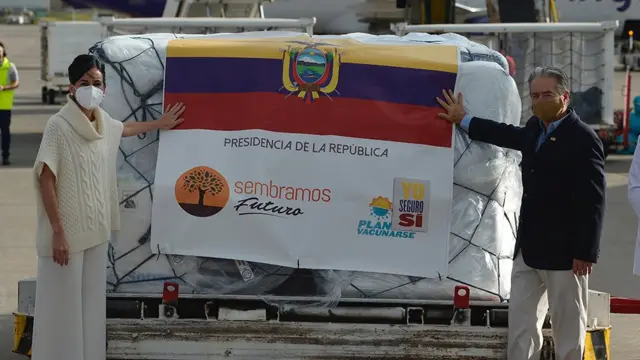 Ministro da Saúde do Equador, Juan Carlos Zevallos, e a vice-presidente do país, María Alejandra Muñoz, posam junto ao primeiro lote da vacina que chegou ao país em 21 de janeiro