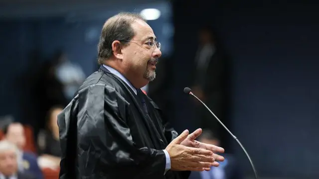 Celso Vilardi usando toga e fazendo a sustentação oral diante de um microfone na Primeira Turma do STF 