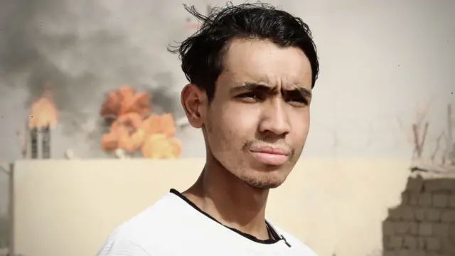 19-year-old from Rumaila in front of gas flaring