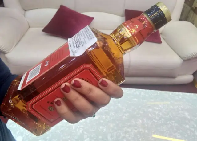 મહિલાના હાથમાં બોટલની તસવીર