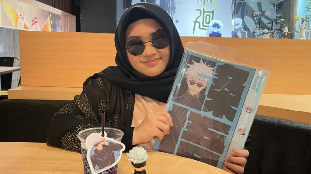 Olive memegang folder Gojo Satoru, karakter favoritnya dalam serial manga Jujutsu Kaisen