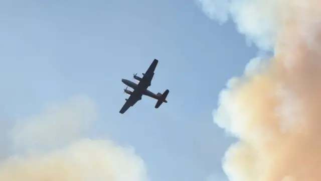 A spotter plane flies above a smoke plume to help fight the "Wall fire" near Oroville, California(09 July 2017)