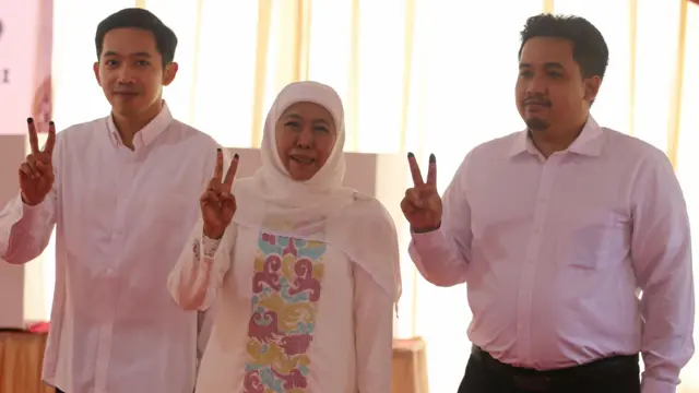 Calon Gubernur Jawa Timur Khofifah Indar Parawansa (tengah) didampingi putranya Jalaluddin Mannagalli Parawansa (kiri) dan Ali Mannagalli Parawansa (kanan) berpose usai mencoblos