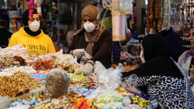 женщины в масках на рынке в багдаде