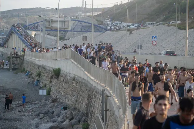 Personas cruzando el paso fronterizo de Ceuta.