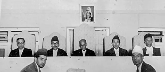 बेन्चमा बसिरहेका प्रधानसहित अन्य मानिस