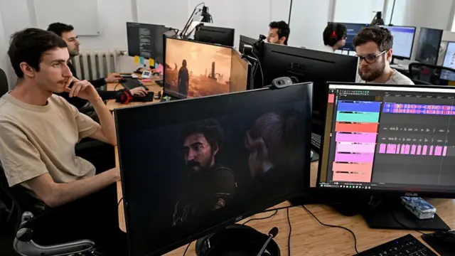 Чоловіки сидять в офісі за моніторами.