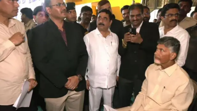 नोटिस देने आये अधिकारियों से बात करते नायडु