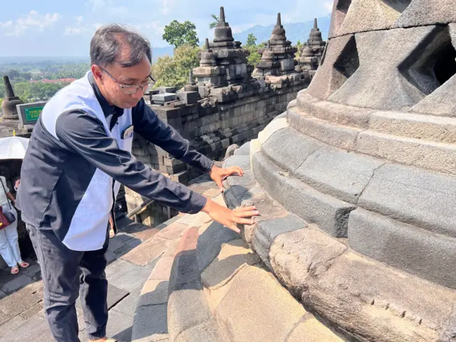 Hari Setyawan menunjukkan lapisan batu yang aus akibat diinjak-injak.