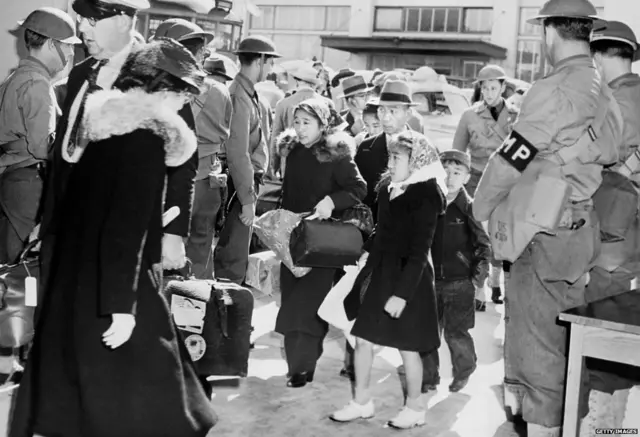 जापानी मूल के अमेरिकी परिवार मई 1942 में सैन फ़्रांसिस्को के एक रिलोकेशन सेंटर जाते हुए.