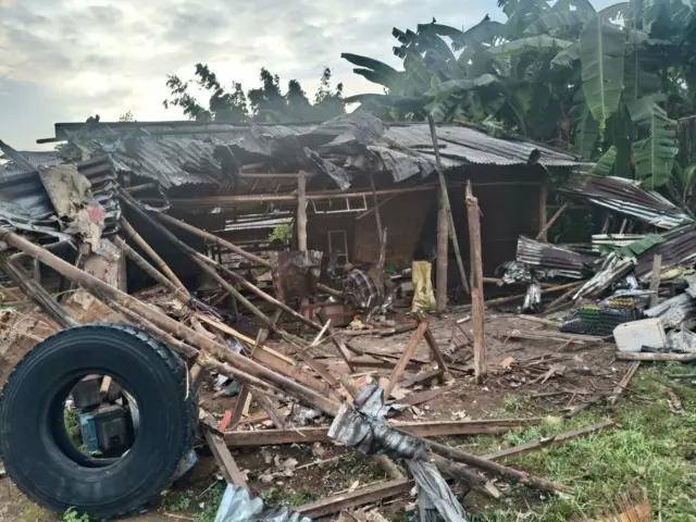 သွပ်မိုးတွေ လန်ထွက်ပျက်စီးနေတဲ့ အိမ်တစ်လုံးမှာ ကျန်ရစ်ပစ္စည်းတွေ ရှာဖွေနေသူ တစ်ဦး 