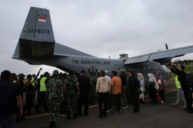 Sejumlah mahasiswa dan warga bersiap menaiki pesawat Cassa U-6211 sebelum berangkat meninggalkan Bandara Rembele, Kabupaten Bener Meriah, Aceh, Selasa (2/12/2025).