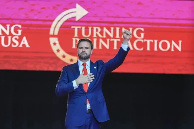 Вэнс поднимает вверх кулак, другую руку прижимает к сердцу