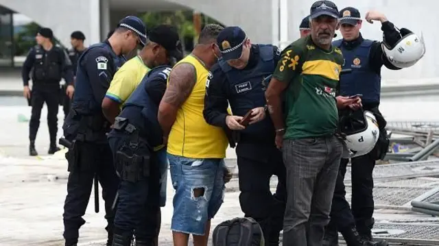 Homens sendo presos pela polícia 