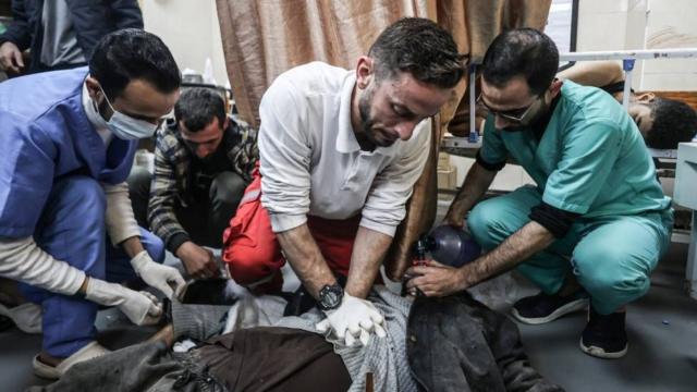 Médico en Gaza intentando salvar a un paciente que está tendido en el suelo
