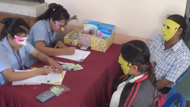 สตรีในพื้นที่ อบต.สระแก้ว อ.เมือง จ.กำแพงเพชร สวมหน้ากากระหว่างรอรับการตรวจคัดกรองมะเร็งเมื่อวันที่ 4 พ.ค.