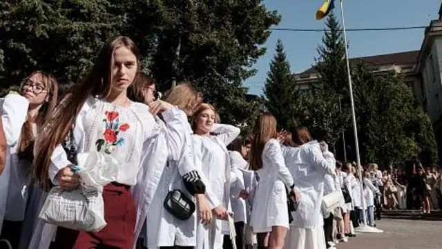 Дівчата у національному вбранні вишикувалися у дворі вишу на урочисту подію.