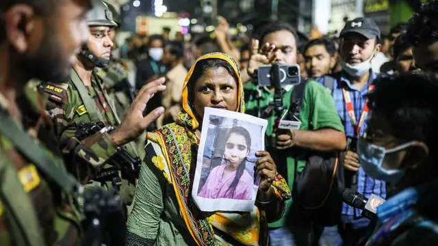 নিখোঁজ স্বজনের ছবি হাতে এক নারী