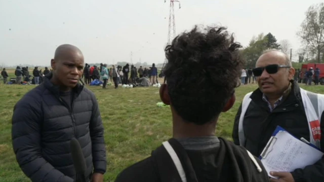 "Irfan", dos à la caméra, parle à Daniel Henry de la BBC (à gauche) via un interprète