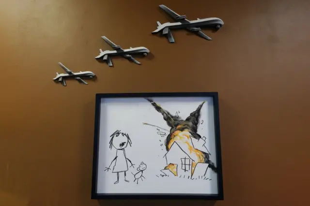 Sanatçı Banksy, Uluslararası Silah Fuarı'nı protesto etmek için kurulan Uluslararası Silah Fuarı Sanat Sergisi'nde bu eserini sergilemişti
