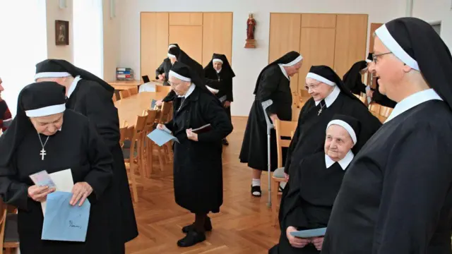 Una congregación de monjas en Italia con sus papeletas de voto en a mano