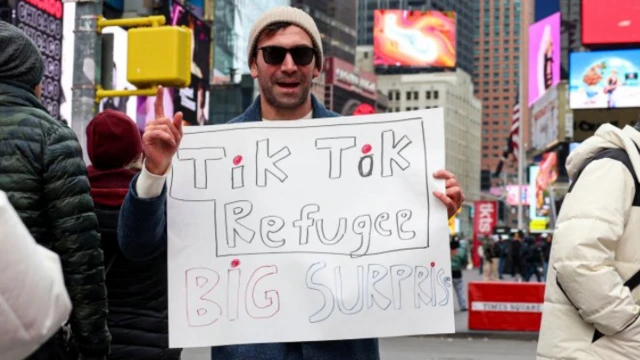 Un hombre en Nueva York sostiene una pancarta que dice "refugiado de TikTok".