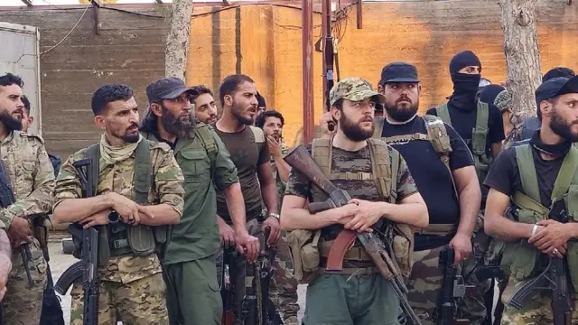 صورة تظهر أفراداً من قوات الأمن السوري ترتدي زياً عسكرياً، ومدججين بالسلاح.