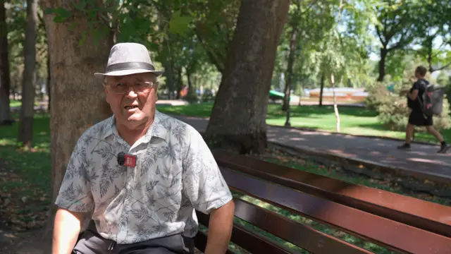 an elderly man sitting on a bench