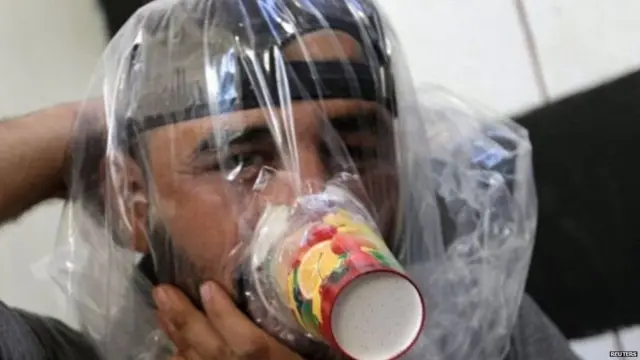 ઇદલિબમાં રાસાયણિક હુમલા સામે રક્ષણની તૈયારી કરતી માસ્કધારી વ્યક્તિ