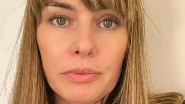 Katie Curran – kobieta o zielonych oczach i blond włosach do ramion.