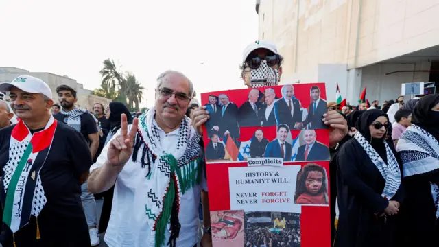 المعارض البحريني البارز إبراهيم شريف يرفع علامة النصر أثناء مشاركته في احتجاج لدعم فلسطين قبل أن تعتقله السلطات