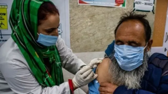 এক বৃদ্ধকে টিকা দেওয়া হচ্ছে।