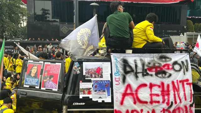 Mahasiswa memegang spanduk di demo pada Selasa (18/08).