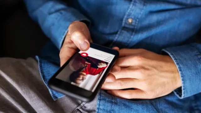 Zbliżenie mężczyzny korzystającego z aplikacji randkowej na telefonie komórkowym. Przycięte ujęcie mężczyzny trzymającego telefon komórkowy i korzystającego z aplikacji randkowej.