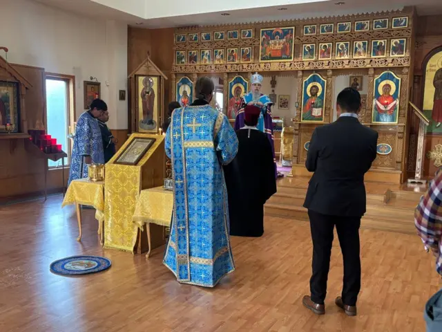 Церковная служба: свуященнослужители в голубых одеждах перед алтарем