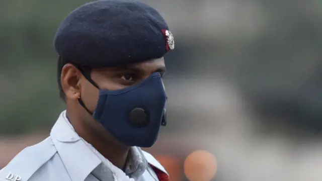 પ્રદૂષણથી બચવા માસ્ક પહેરી ઉભેલા જવાનની તસવીર